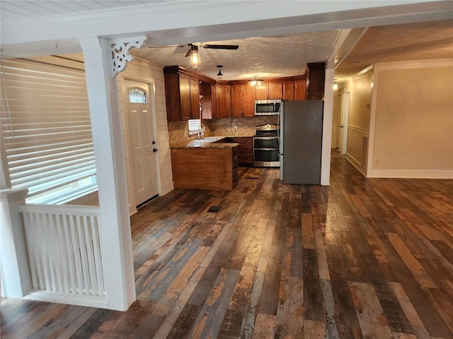 kitchen featuring tasteful backsplash, sink, ornamental molding, stainless steel appliances, and dark hardwood / wood-style floors