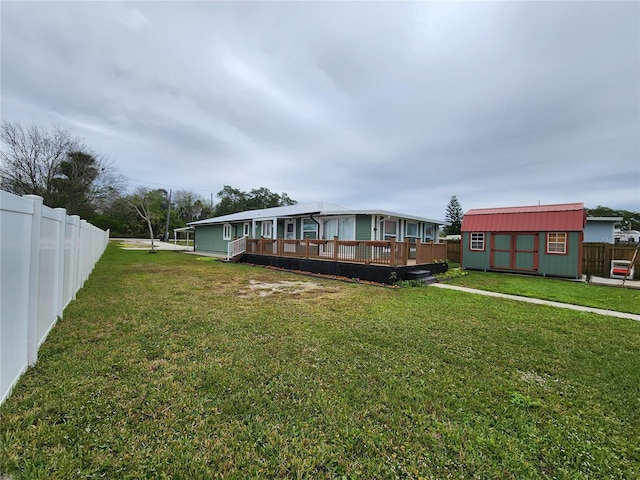 exterior space featuring a storage unit, a wooden deck, and a front lawn