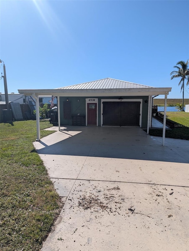 garage featuring a carport and a lawn