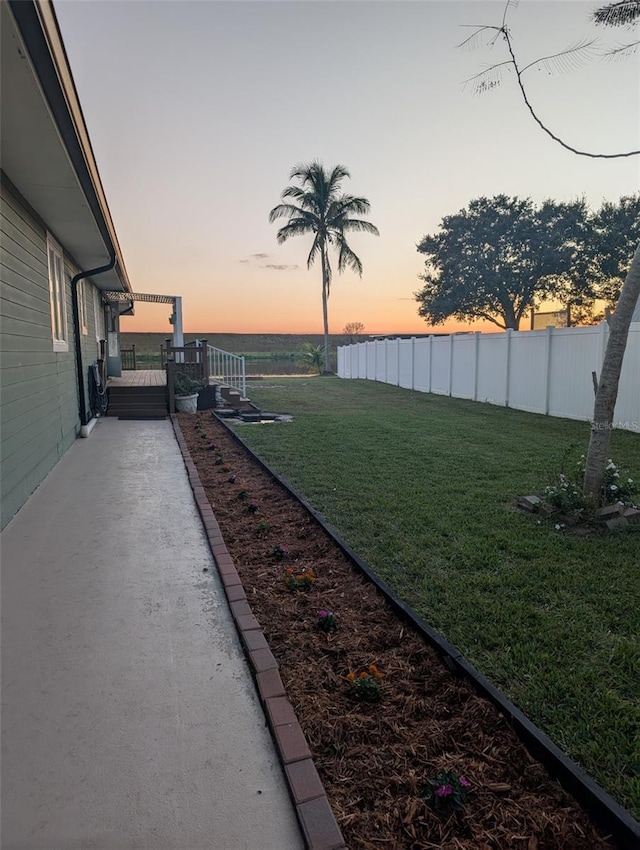 yard at dusk featuring a deck