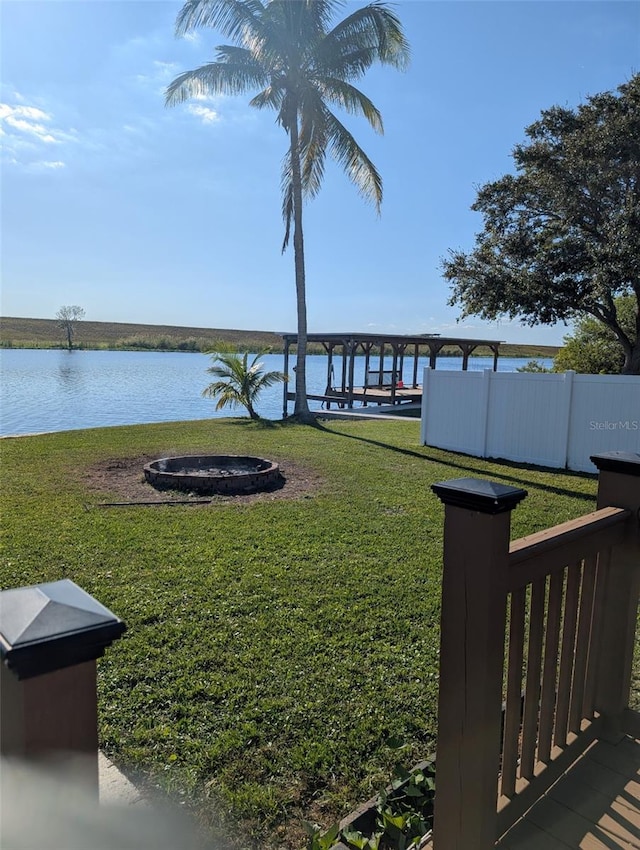 view of yard with an outdoor fire pit and a water view