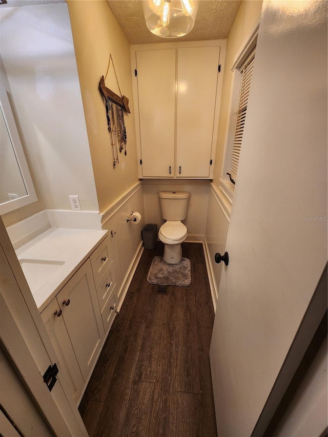 bathroom featuring hardwood / wood-style floors, toilet, vanity, and a textured ceiling