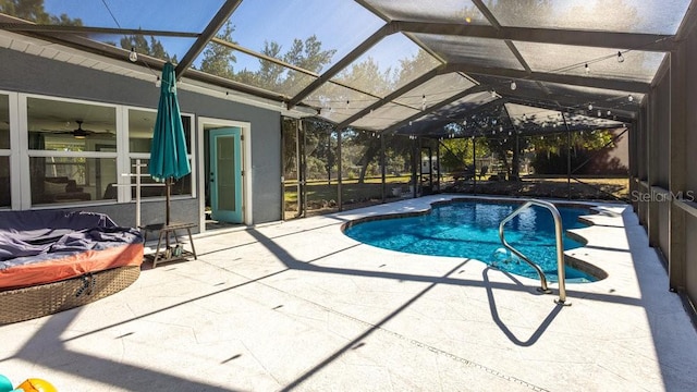 view of pool featuring glass enclosure, ceiling fan, and a patio