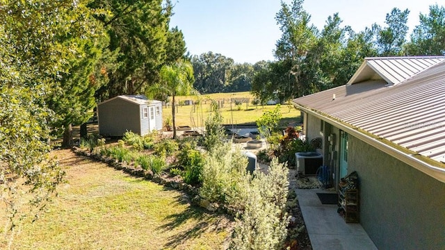 view of yard featuring cooling unit and a storage shed