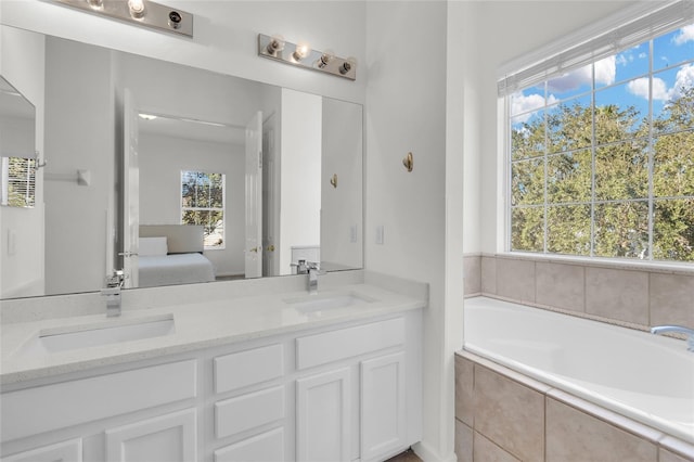 bathroom with vanity and tiled bath