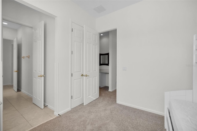 unfurnished bedroom with light colored carpet and a closet