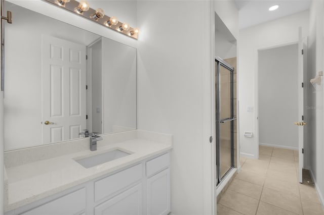 bathroom with tile patterned flooring, vanity, and walk in shower