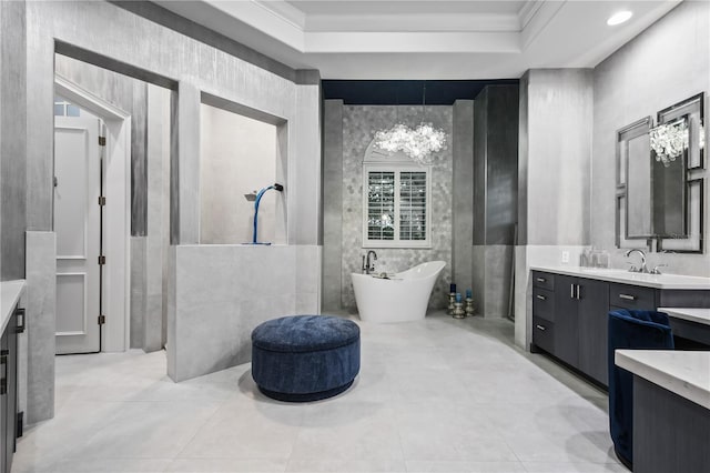 bathroom featuring a raised ceiling, a bathing tub, ornamental molding, and vanity