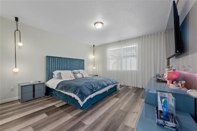 bedroom featuring hardwood / wood-style floors and a textured ceiling