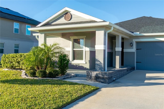 view of exterior entry featuring a porch, a garage, and a lawn