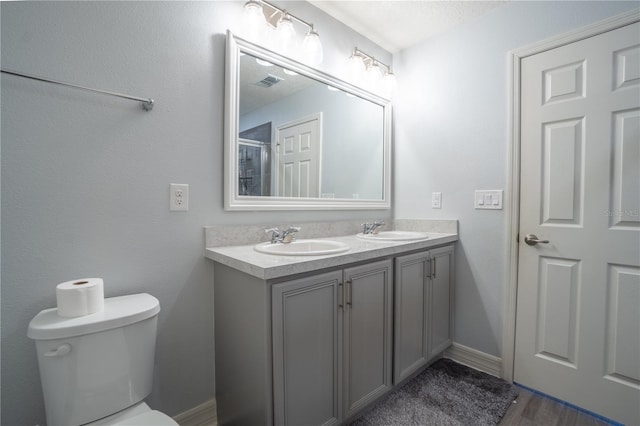 bathroom featuring toilet, vanity, and hardwood / wood-style flooring