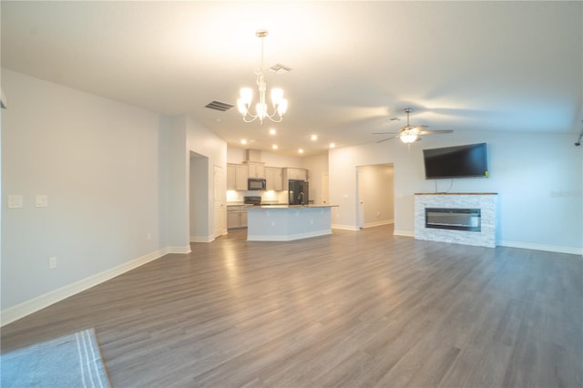 unfurnished living room featuring a fireplace, ceiling fan with notable chandelier, and dark hardwood / wood-style floors