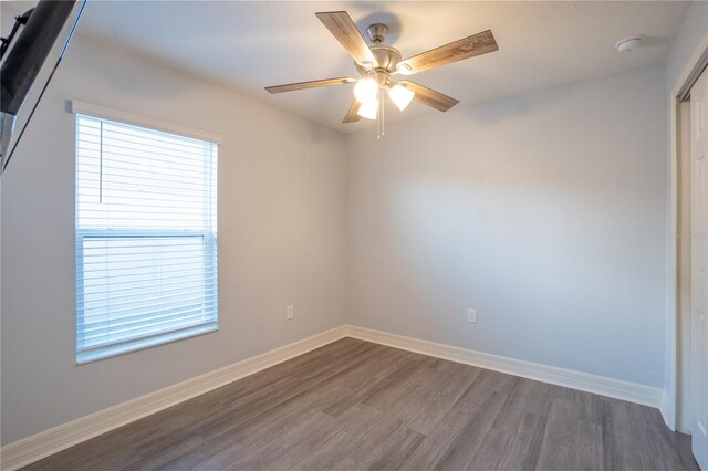 unfurnished room with ceiling fan and dark hardwood / wood-style flooring