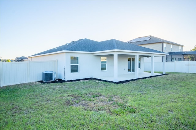 back of property featuring a yard, a patio, and central AC