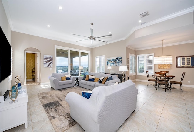 living room with light tile patterned floors, ceiling fan with notable chandelier, and ornamental molding