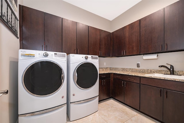 washroom with cabinets, independent washer and dryer, light tile patterned flooring, and sink