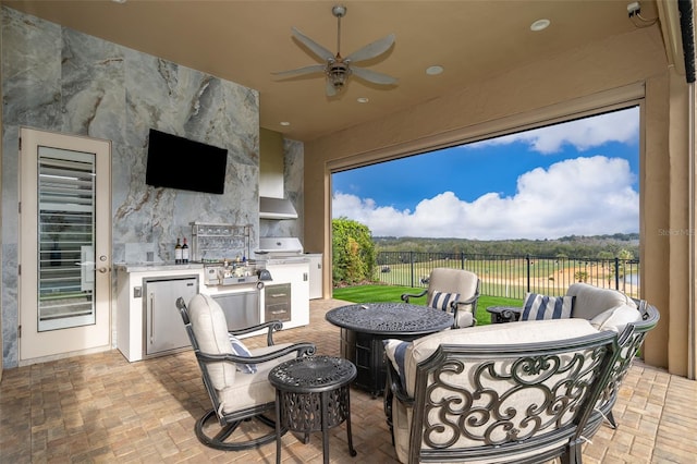 view of patio with outdoor lounge area, ceiling fan, an outdoor kitchen, wine cooler, and area for grilling