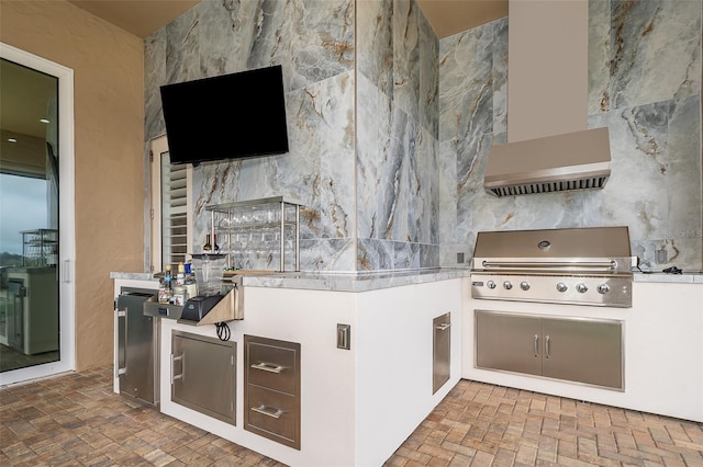 kitchen with white cabinets, exhaust hood, and tile walls