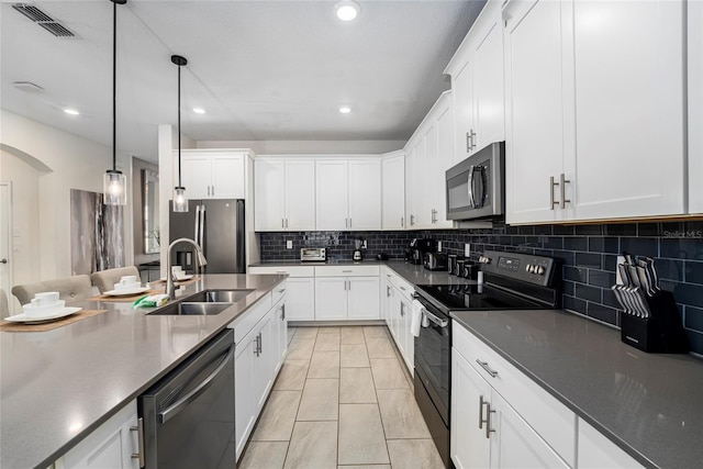 kitchen featuring hanging light fixtures, white cabinets, stainless steel appliances, and sink