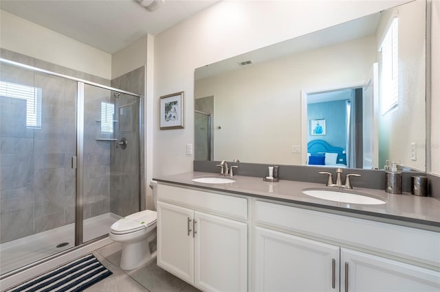 bathroom with tile patterned flooring, vanity, toilet, and a shower with shower door