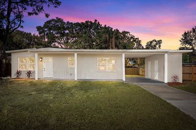 single story home featuring a carport and a yard