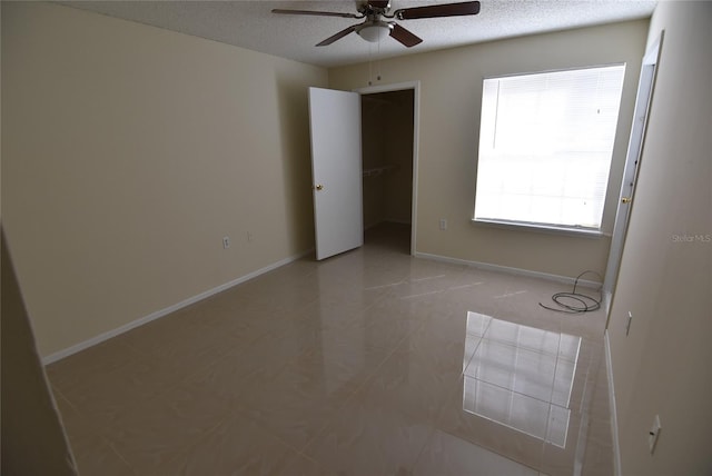 empty room featuring a textured ceiling and ceiling fan