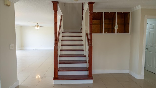 stairs with tile patterned flooring, a textured ceiling, and ceiling fan