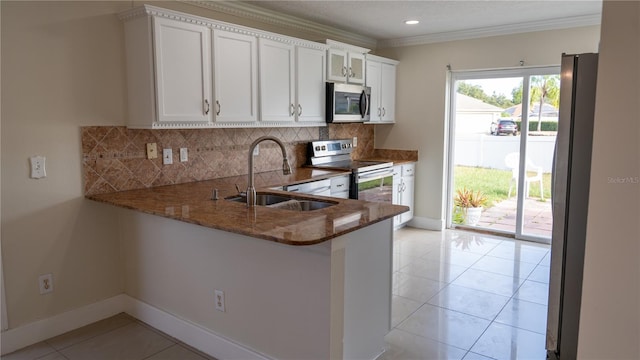 kitchen with kitchen peninsula, sink, white cabinets, and appliances with stainless steel finishes