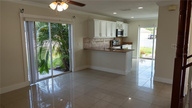 kitchen with white cabinetry, crown molding, decorative backsplash, light tile patterned flooring, and appliances with stainless steel finishes