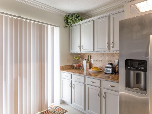 kitchen featuring stainless steel refrigerator with ice dispenser, a textured ceiling, crown molding, stone counters, and light tile patterned flooring