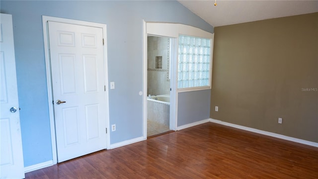 unfurnished bedroom with dark hardwood / wood-style flooring and vaulted ceiling