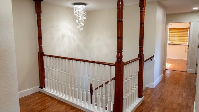 hall with hardwood / wood-style flooring and a notable chandelier