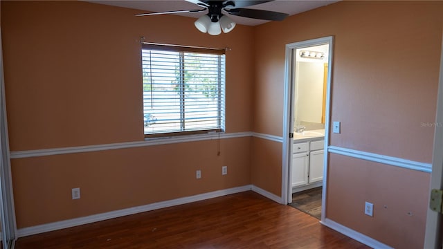 unfurnished bedroom with ensuite bath, ceiling fan, dark wood-type flooring, and sink