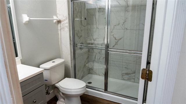 bathroom featuring wood-type flooring, vanity, toilet, and an enclosed shower