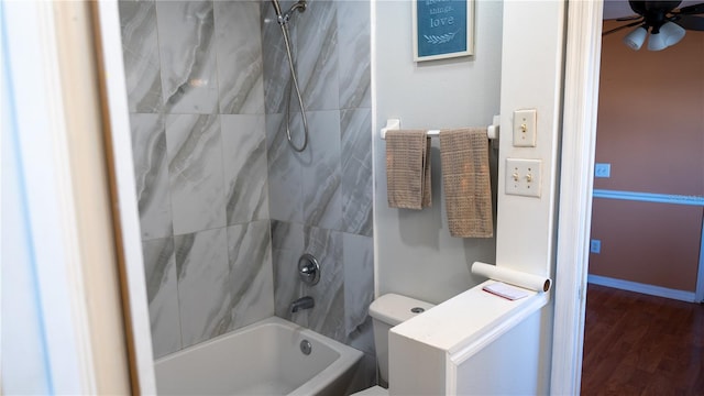 bathroom featuring hardwood / wood-style flooring, ceiling fan, toilet, and tiled shower / bath