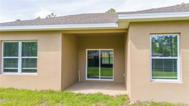 view of exterior entry with a patio