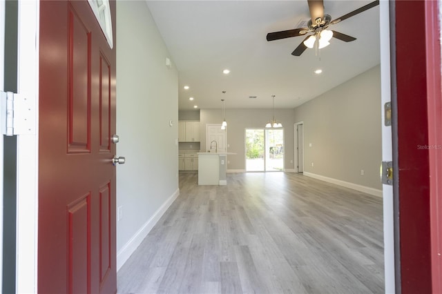 interior space with ceiling fan, sink, and light hardwood / wood-style floors