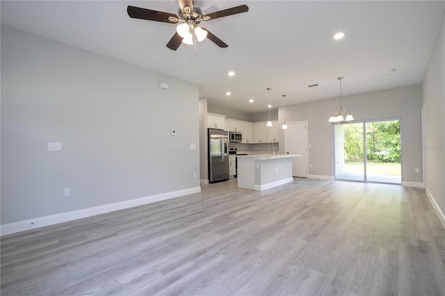 kitchen featuring a center island, light hardwood / wood-style floors, white cabinets, ceiling fan with notable chandelier, and appliances with stainless steel finishes