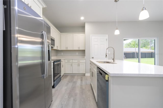 kitchen with hanging light fixtures, sink, appliances with stainless steel finishes, light hardwood / wood-style floors, and white cabinetry