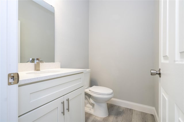 bathroom featuring toilet, vanity, and hardwood / wood-style flooring