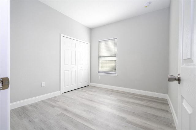 unfurnished bedroom featuring a closet and light hardwood / wood-style flooring