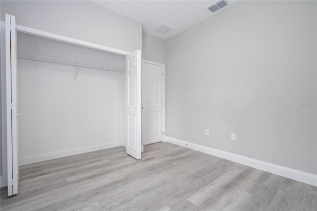 unfurnished bedroom with light wood-type flooring and a closet