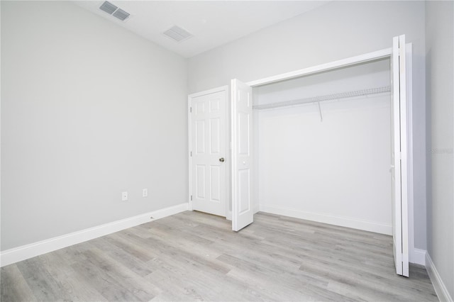 unfurnished bedroom featuring a closet and light hardwood / wood-style flooring