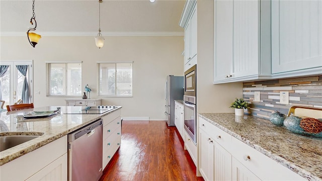 kitchen with stainless steel appliances, white cabinetry, pendant lighting, and decorative backsplash