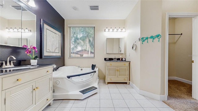 bathroom with vanity, a tub, and tile patterned floors