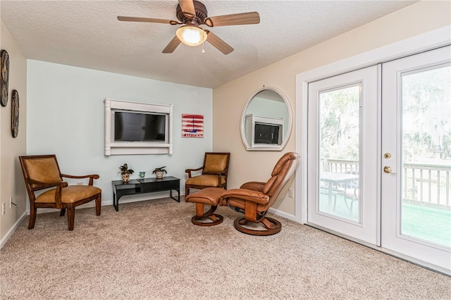 living area featuring french doors, a textured ceiling, light carpet, and ceiling fan