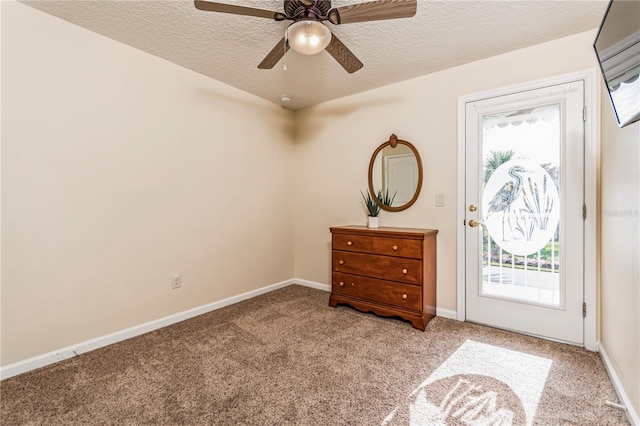 carpeted entrance foyer featuring a textured ceiling and ceiling fan