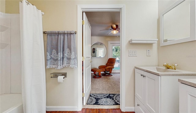 bathroom featuring a textured ceiling, shower / tub combo with curtain, hardwood / wood-style floors, ceiling fan, and vanity