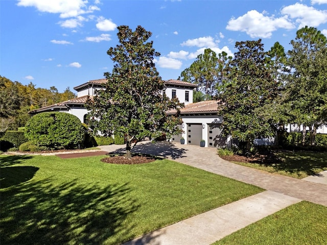 mediterranean / spanish-style house with a front yard and a garage