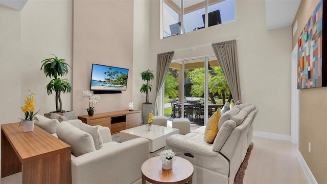 carpeted living room featuring a towering ceiling